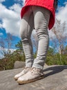 Female legs in lifght jeans and white leather boots  on mountain top Royalty Free Stock Photo