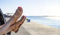 Female legs out of a car window on a background of sky. Royalty Free Stock Photo