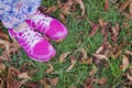 Female legs in pink sport sneakers on green grass Royalty Free Stock Photo