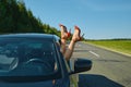 Female legs in red shoes sticking out of the wind window of a car Royalty Free Stock Photo