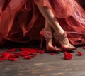 Female legs in red shoes on a wooden floor with rose petals Royalty Free Stock Photo