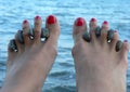 Female legs on sea procedures with stones between fingers