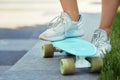 female legs standing on blue skateboard in park Royalty Free Stock Photo