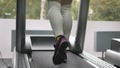 Female legs walking and running on treadmill in gym. Young woman exercising during cardio workout. Feet of girls in Royalty Free Stock Photo