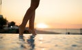Female legs in the water at sunset Royalty Free Stock Photo