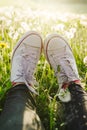 Female legs in white canvas sneakers and black jeans Royalty Free Stock Photo