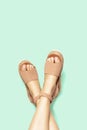 Female legs with white pedicure in summer brown sandals on background, copy space Royalty Free Stock Photo