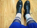 Female legs in white socks and stylish green shoes. Fashion trends.