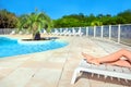 Female legs on a white sun lounger. Beautiful woman relaxing by the swimming pool with water Royalty Free Stock Photo