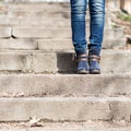 Female legs in winter boots and jeans on stairs Royalty Free Stock Photo