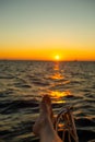 Female legs on yachr, sunrise on background