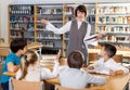 Female librarian and schoolkids during classes Royalty Free Stock Photo