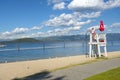 A female lifeguard stands on duty at her lifeguard station along the sandy city beach at Sandpoint, Idaho