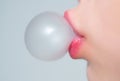 Female lips blowing pink bubble gum. Closeup of a woman face with pink lips and gum bubble. emale lips holding shiny Royalty Free Stock Photo