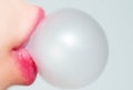 Female lips blowing pink bubble gum. Closeup of a woman face with pink lips and gum bubble. emale lips holding shiny Royalty Free Stock Photo