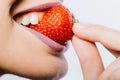 Female lips eating red strawberry. Woman mouth with sexy lips eating red sweet strawberry berry fruit, closeup. Royalty Free Stock Photo