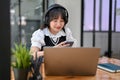 A female listening to music while remote working at the coffee shop on the weekend Royalty Free Stock Photo