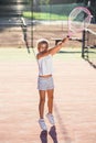 Female little tennis player in white sport uniform practice in hitting with tennis racket at the training on outdoor Royalty Free Stock Photo