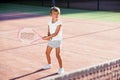 Female little tennis player in white sport uniform practice in hitting with tennis racket at the training on outdoor Royalty Free Stock Photo