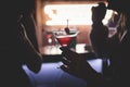 Female lonely girl glam blond woman using smartphone with dating app site is drinking in a bar on a counter with different