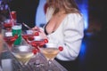 Female lonely girl glam blond woman using smartphone with dating app site is drinking in a bar on a counter with different