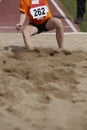 Female long jump competition with woman fallin in the sand