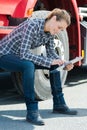 female lorry driver sat on cab step looking at clipboard Royalty Free Stock Photo