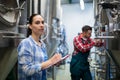 Female maintenance worker testing brewery machine