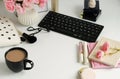 Female make up accessories, cup of cofee and bouquet of pink roses on white background. Flat lay, top view feminine desk, workspac