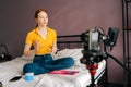 Female make-up artist and blogger with red hair recording video about face contouring for vlog using professional camera Royalty Free Stock Photo