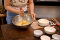 A female whisking her softened butter, sugar, eggs and flour together in the mixing bowl