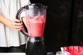 Female making watermelon smoothie with blender