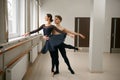 Female and male ballet dancers dancing at barre Royalty Free Stock Photo