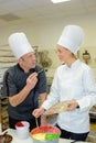 Female and male chefs decorating pastries