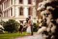 Female and male couple have walk outdoor with their favourite dog, train it, stroll in open air across green path and Royalty Free Stock Photo