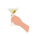 Female or male hand holding martini glass with classic cocktail garnished with green olives. Glass with alcohol drink Royalty Free Stock Photo