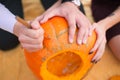 Female and Male hands carve a pumpkin for Halloween. A couple on a picnic in the fall on Halloween Royalty Free Stock Photo