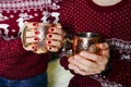 Female and male hands with glass cup of delicious Christmas mulled wine Royalty Free Stock Photo