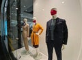 Female and male mannequins in red masks and autumn clothes stand in a shop window in the shopping center `Mega` in Moscow