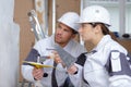 female and male plasterer at indoor wall renovation decoration