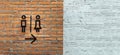Female / Male restroom. Sex symbol on red brick wall and white brick as background. Toilet icon, Restroom Concept Royalty Free Stock Photo