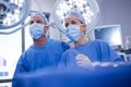 Female and male surgeon wearing surgical mask in operation theater Royalty Free Stock Photo