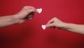 Female and male waving in hands little white hearts isolated on red background.