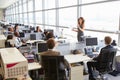 Female manager addressing workers in open plan office Royalty Free Stock Photo