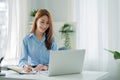 Asian businesswoman working with tiger skins notebooks graphs documents at modern desks using computers successful female e-commer