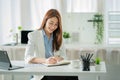 Asian businesswoman working with tiger skins notebooks graphs documents at modern desks using computers successful female e-commer