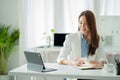 Asian businesswoman working with tiger skins notebooks graphs documents at modern desks using computers successful female e-commer