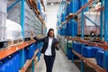 Female manager checking stocks while using digital tablet in warehouse