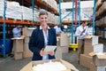 Female manager with digital tablet looking at camera in warehouse Royalty Free Stock Photo