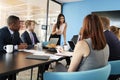 Female manager stands addressing team at business meeting Royalty Free Stock Photo